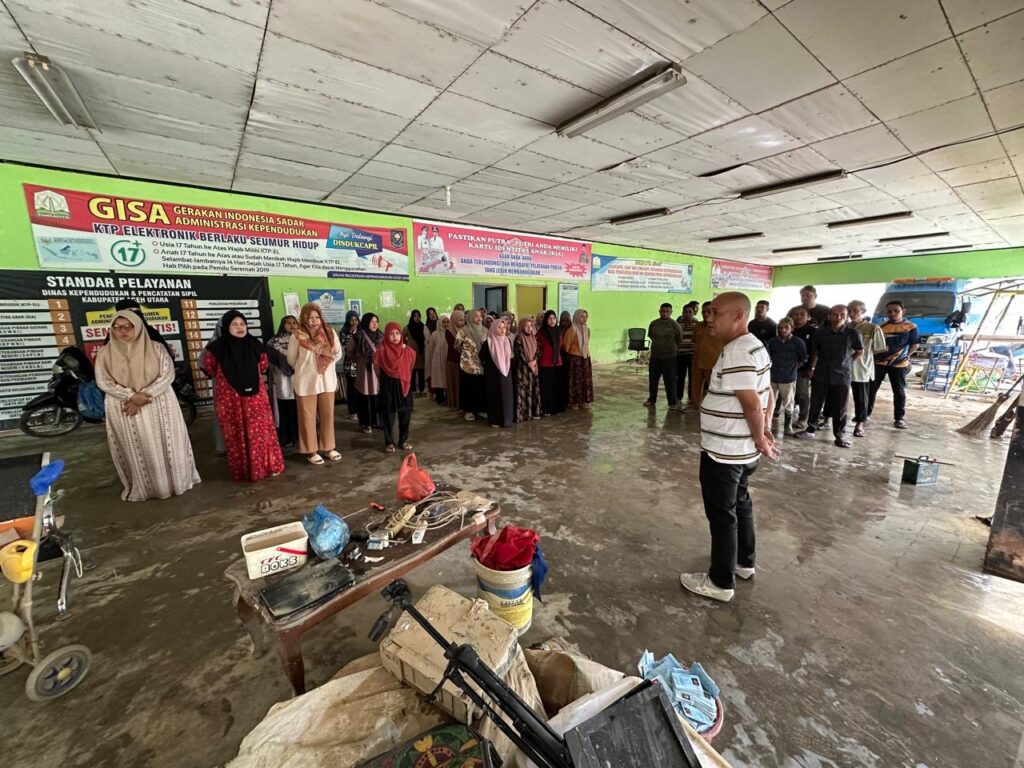Pegawai Disdukcapil Aceh Utara membersihkan kantor pasca bencana hidrometeorologi untuk memulihkan layanan administrasi kependudukan.