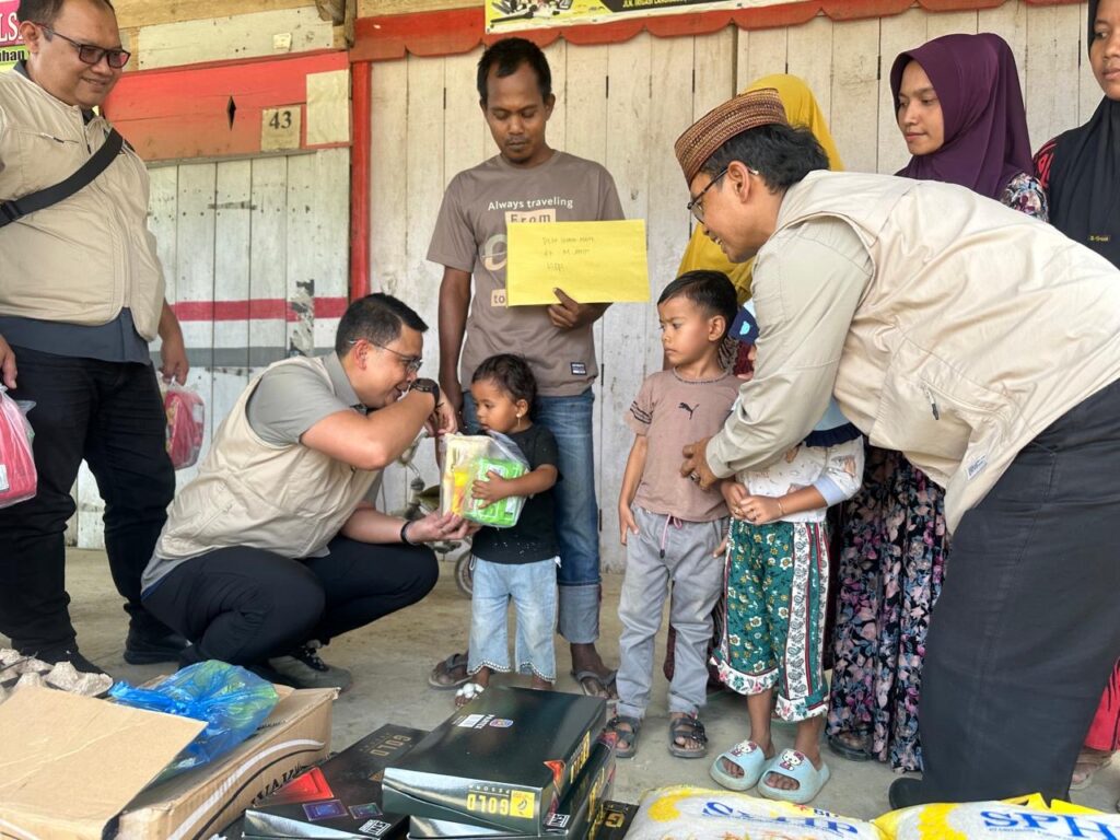 Direktur PIAK Ditjen Dukcapil menyerahkan makanan ringan kepada anak-anak korban banjir di Kecamatan Langkahan Aceh Utara