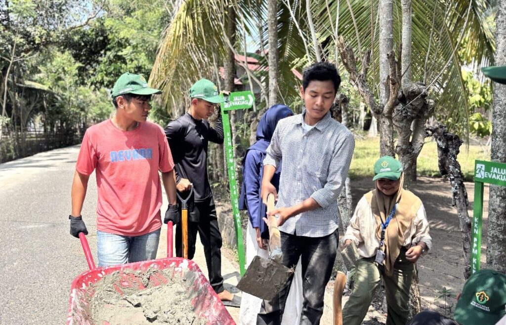 Mahasiswa KKN Universitas Malikussaleh memasang plank jalur evakuasi di Desa Kuala Blang Mangat Lhokseumawe untuk mitigasi bencana.