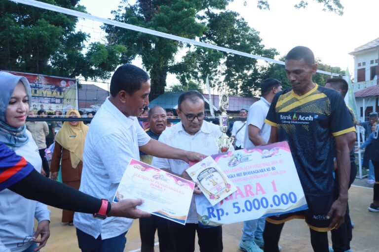 Kapolres Lhokseumawe menyerahkan trofi juara Turnamen Voli Legend Aceh kepada Tim Bank Aceh pada Hari Bhayangkara ke-80