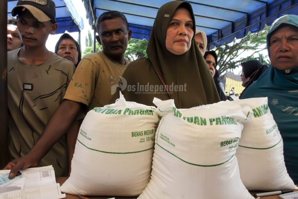 BERAS PANGAN BANTUAN PEMERINTAH: Warga antre untuk mendapatkan beras bantuan pangan dari Pemerintah yang disalurkan di Desa Tumpok Tengoh, Kota Lhokseumawe, Provinsi Aceh, Senin (24/8/2026). Pemerintah melalui Perum Bulog menyalurkan sebanyak 682.110 ton beras bantuan periode Agustus dan September 2026 kepada 8000 keluarga penerima manfaat (KPM) dengan total 30 kilogram per penerima untuk membantu memenuhi kebutuhan pokok masyarakat berpenghasilan rendah dan upaya Pemerintah menekan inflasi daerah. POS INDEPENDENT/Mamex01